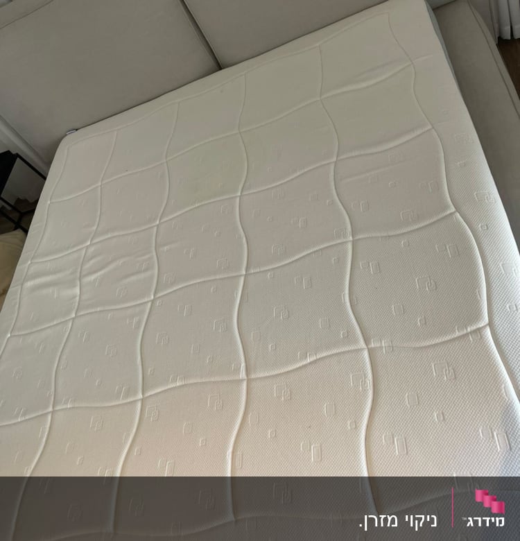 מזרן לבן על ספה אפורה